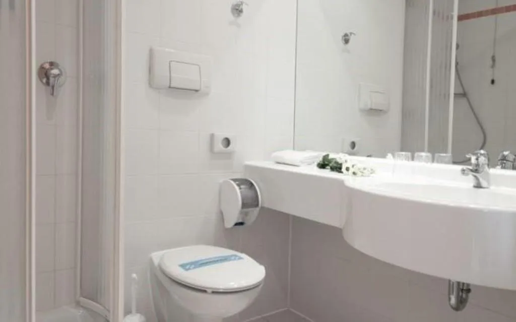 Bagno moderno bianco con doccia, lavabo, WC e specchio